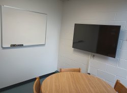 Table and chairs with monitor and whiteboard