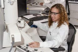 Woman sitting at large microscope in a lab