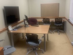 Conference room with table, chairs, and monitor