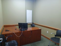 Study room with table, chairs, computer, and whiteboard