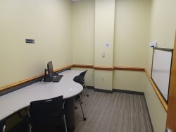 Study room with table, chairs, computer, and whiteboard