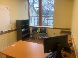 Study room with table, chairs, computer, whiteboard, and shelf