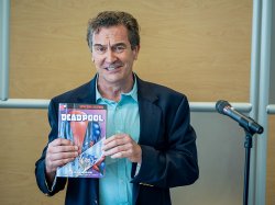 man holding a deadpool book