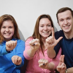 Image of three students signing A-S-L in American Sing Language