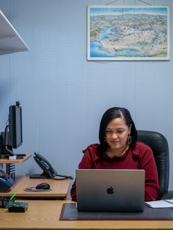 Aracelis Ruiz sitting at desk with laptop