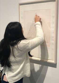 student studying piece of artwork