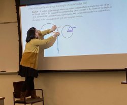 Karmen Yu teaching radians standing on a chair to explain her slide on the subject