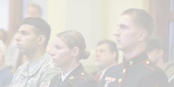 faded photo of service members in audience at event
