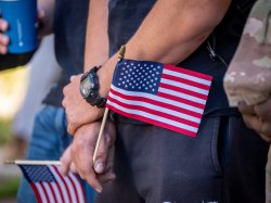 Student veteran holds small US flag.