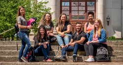 Group of students sitting on a step outside