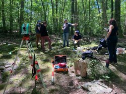students outside in wooded area using mapping technology