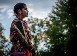 photo of indigenous woman standing infont of blue sky