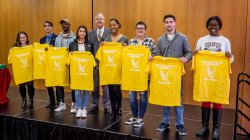 Studens from University College signing day holding up yellow shirts
