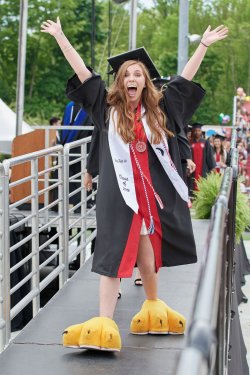 Female Montclair State University student wearing cap and gown and Rocky's feet