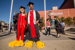 Students wearing Rocky's feet at Commencement