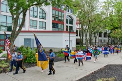 Student holding Latino Pride banner leading other students each holding Latin American country flag