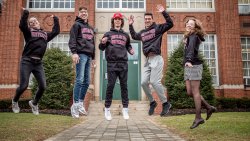 The Povolo quintuplets wear Montclair State University shirts and jump for joy for scholarship offers outside of Passaic Valley High School