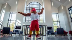 Rocky the Red Hawk standing in College Hall with arms outspread