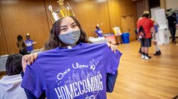 Student holding up her homecoming tee-shirt after registering