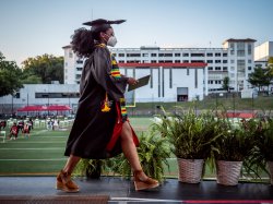 student walks across stage during undergraduate commencement ceremony