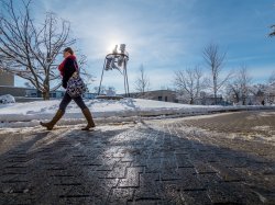 Photo of a student walking across the snowy campus of Montclair State University
