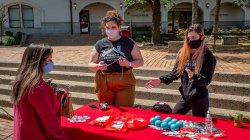 students conversing across a club table littered with give-aways