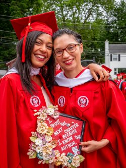 Two graduates in the graduate school red regalia