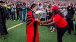 Dr. Cole shaking hands with a parent attending commencement
