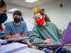 Three students in masks in a classroom