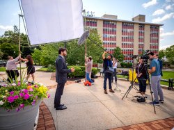 President Koppel recording his welcome message in front of a camera crew.