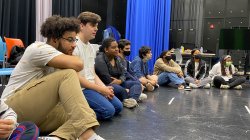 Close view of students sitting on the floor in television studio