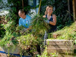 two student voluteers clearing weeds