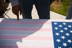 poster of American flag where the strips are made from the names of lives lost on september 11