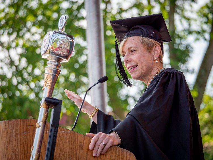 Nancy Erika Smith in cap and gown at podium