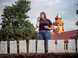 Mikaela Benkert singing with luminaria in the foreground