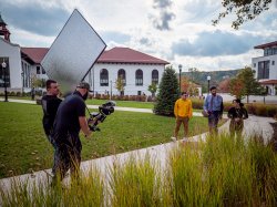 The film crew recording President Koppell walking with two students