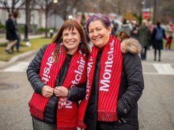 Two attendees smiling for the camera wearing Montclair State University scarves