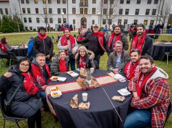faculty and staff gathered at a table for the outdoor winter celebration