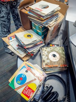 A close up photo of a table with many 45 records
