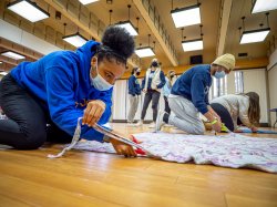 Student volunteers cutting fabric for blankets