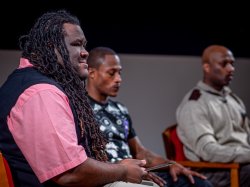 Justice Studies Professor and moderator Jason Williams, forefront, listens during a question from the audience.