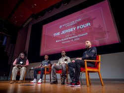 Photo of Montclair State University Professor of Justice Studies Jason Williams on stage with members of the Jersey Four