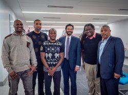 (L to R) Jarmaine Grant, Danny Reyes, Rayshawn Brown, President Jonathan Koppell, Professor Jason Williams and University Foundation Chairman Greg Collins, pose momentarily without masks for a photo.