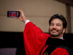 A photo of Montclair State President Jonathan Koppell taking a selfie with the crowd on stage