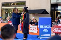 Student Aminata Coundoul receiving her pin