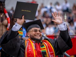 graduate holding up diploma holder