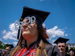 Photo of a graduate wearing novelty singlasses that say graduate