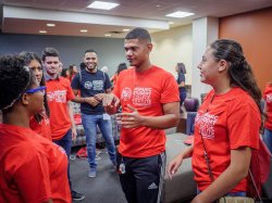 photo of an instructor in a red t-shirt with students from Montclair State's Hispanic Student College Institute