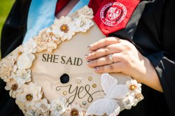 close up photo of a graduate's mortar boards with the words she said yes printed on it.