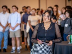 student leaning against high-top table